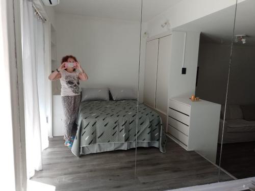 a woman taking a picture of a bedroom with a mirror at Dorado in Buenos Aires