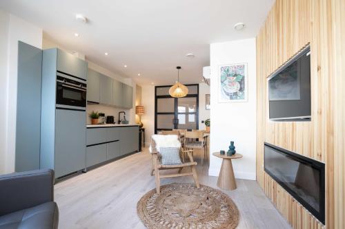 a living room with a couch and a kitchen at Modern two bedroom apartment close to the beach in Scheveningen