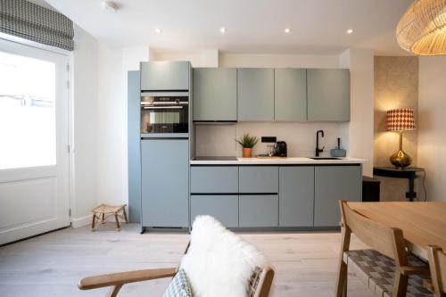 a kitchen with white cabinets and a blue refrigerator at Four Star Apartments - Badhuisstraat 6 in Scheveningen