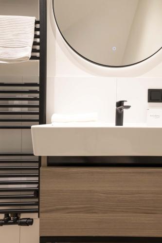 a bathroom with a white sink and a mirror at Modern two bedroom apartment close to the beach in Scheveningen
