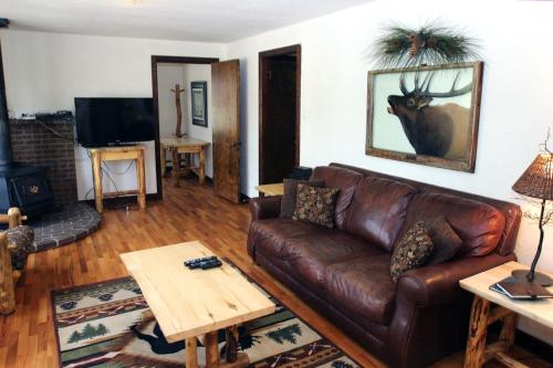 sala de estar con sofá de cuero marrón y mesa en Stonehaven Home by Rocky Mountain Resorts- #3384, en Estes Park