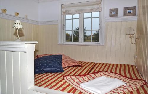SønderhoにあるLovely Home In Fan With Kitchenの窓と枕が備わる部屋のベッド1台分です。