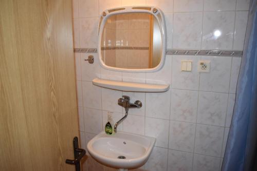 a small bathroom with a sink and a mirror at Penzión Ivana in Bardejov