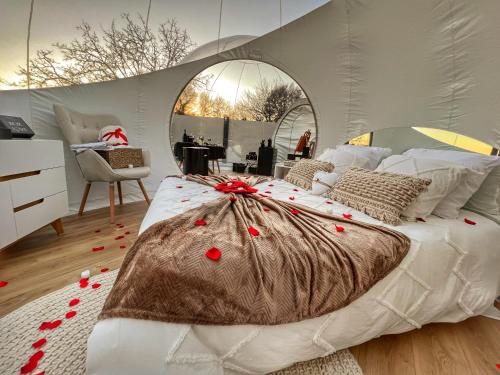a bedroom with a bed with red rose petals on it at Bulles gonflables Love Room - Love Home XO in Richemont