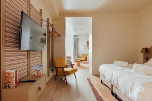 a bedroom with a bed and a flat screen tv at Hôtel Préfecture - Entrée autonome, réception en ligne - Encore Mieux in Limoges