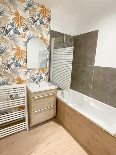une salle de bain avec une baignoire, un lavabo et un miroir dans l'établissement Joli appartement hyper-centre, à Aleçon