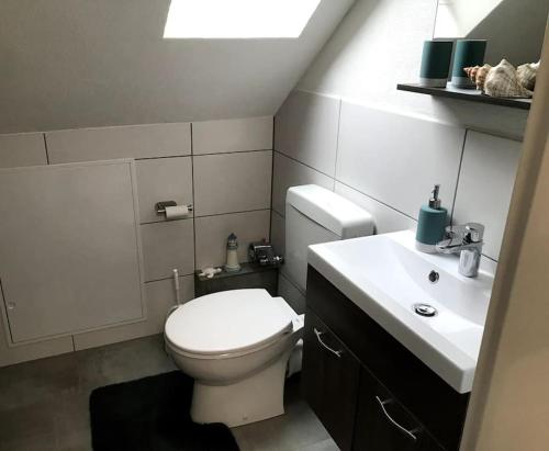 La salle de bains est pourvue de toilettes blanches et d'un lavabo. dans l'établissement 1 Zi Apartment im Stadtzentrum, à Schwalmstadt