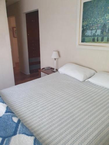 1 dormitorio con 1 cama grande con manta a rayas en en lo de Dan en Buenos Aires
