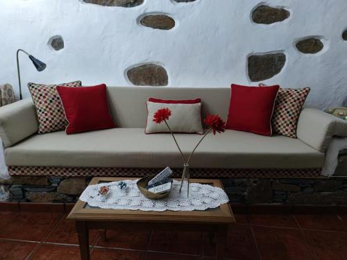 a living room with a couch with pillows and a table at La Casona Del Almendro in San Bartolomé de Tirajana