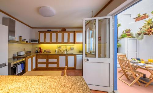 a kitchen with wooden cabinets and a table at Cantinho do Cantagalo in Angra do Heroísmo