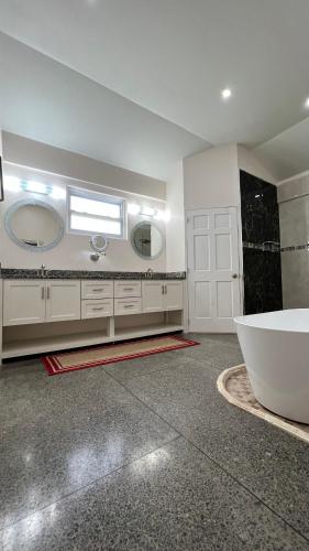 a bathroom with a large tub and a large mirror at Stonetrail in Arnos Vale