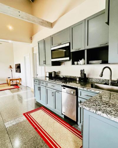 a kitchen with white cabinets and a red rug on the floor at Stonetrail in Arnos Vale
