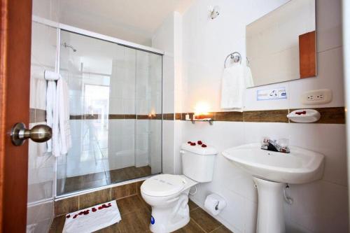 Hotel Hacaritama Colonial في فيلافيسينسيو: حمام ابيض مع مرحاض ومغسلة