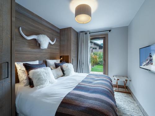 une chambre avec un grand lit blanc dans une pièce dans l'établissement Charmant appartement à Rochebrune avec jardin pour 6 personnes – Accès piscine, salle de sport, sauna - FR-1-569-24, à Megève