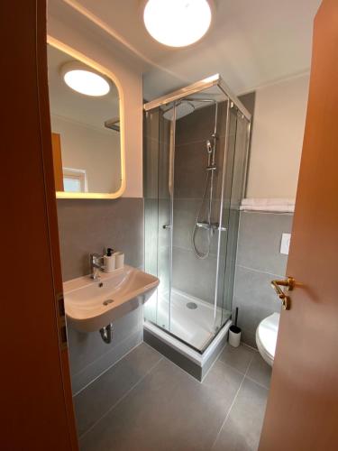 uma casa de banho com um chuveiro, um lavatório e um WC. em Zur Waldlust em Frankfurt