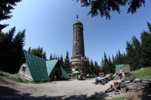 a lighthouse in the middle of a park with a building at Vybavená garsonka v cihlovém domě v centru in Jeseník