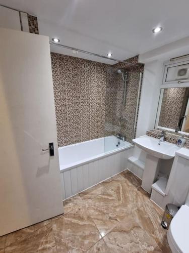 y baño con bañera, lavabo y aseo. en Cosy 3 bed Apt/contractors/families/free parking, en Birmingham