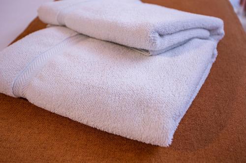 a pile of white towels sitting on top of a table at Hotel Praia do Portinho in Ilhabela