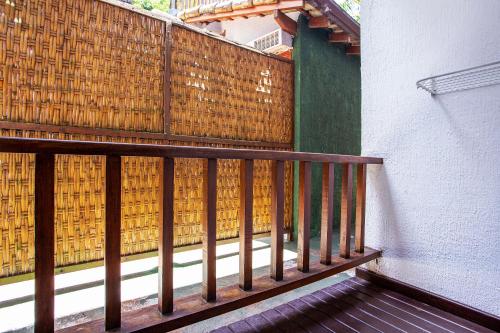 a balcony with a wooden railing and a fence at Hotel Praia do Portinho in Ilhabela