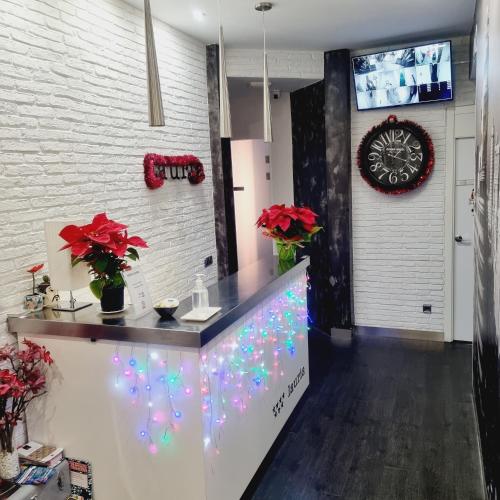 a restaurant with a counter with red flowers and lights at Hostal Lauria in Madrid