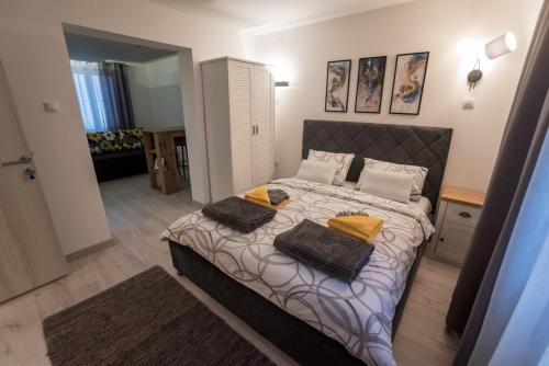 a bedroom with a bed with two towels on it at Tanis Apartments in Niš