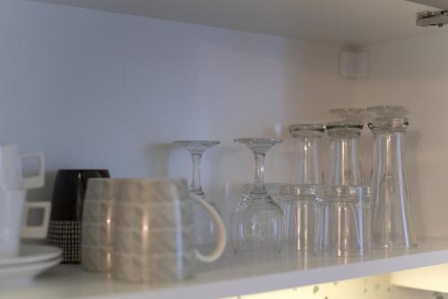a row of wine glasses sitting on a shelf at Tanis Apartments in Niš