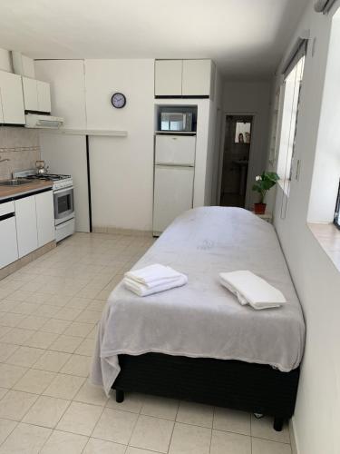 a bedroom with a large bed with two towels on it at Depto Gales, a 1 cuadra del mar in Puerto Madryn