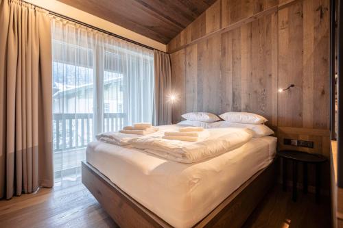 un grande letto in una stanza con una grande finestra di Villa Liesl by ALPS RESORTS a Haus im Ennstal