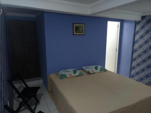 a blue bedroom with a bed and a chair at Casa da Lu in Olinda