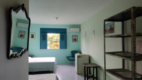a room with a bedroom with a bed and a mirror at Refúgio da Mangueira in Barra dos Coqueiros