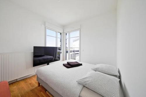 a white bedroom with a bed and a couch at Villa Riviera Near Disneyland Paris in Chessy