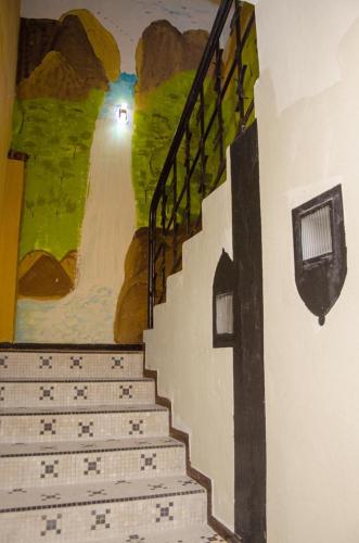 a painting of a staircase with a painting on the wall at Kër Adja in Ziguinchor