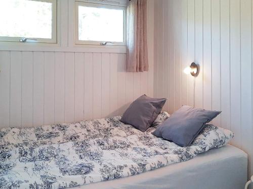 a bed with two pillows on it in a room at Holiday home Søndeled in Søndeled