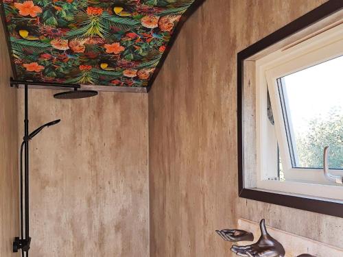 a bathroom with a flower mural on the ceiling at Holiday home Søndeled in Søndeled