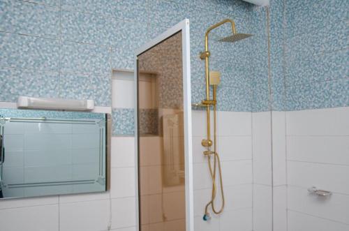 a bathroom with a shower and a mirror at Kër Adja in Ziguinchor