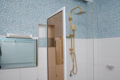 un baño con ducha y espejo en Kër Adja, en Ziguinchor