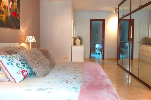 a bedroom with a bed with a lamp and a mirror at Amplio ático con terraza en Andorra centro in Escaldes-Engordany