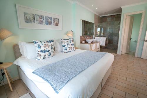 a bedroom with a large white bed with pillows at P146A13 - Eden Island Self Catering Apartment Self Check In in Eden Island