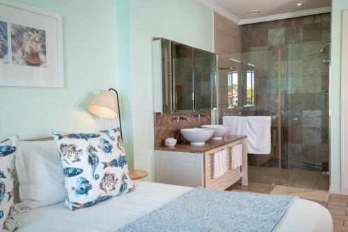 a bathroom with a bed and a shower and a sink at P146A13 - Eden Island Self Catering Apartment Self Check In in Eden Island