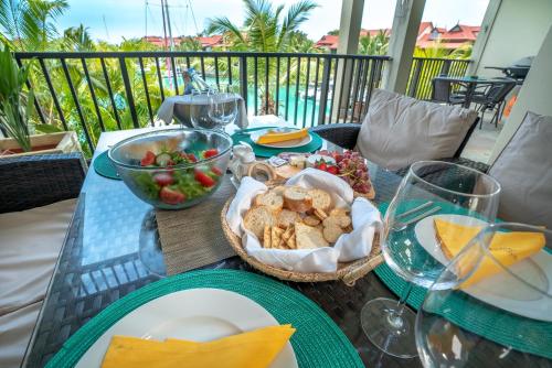 a table with a basket of food and a bowl of fruit at P146A13 - Eden Island Self Catering Apartment Self Check In in Eden Island