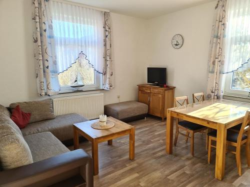 ein Wohnzimmer mit einem Sofa und einem Tisch in der Unterkunft Seevilla Wietjes Whg 2 in Baltrum