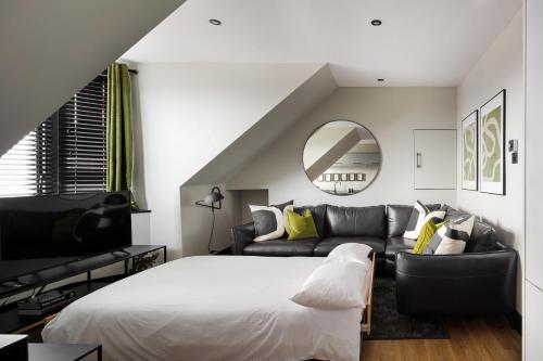 a bedroom with a bed and a couch and a mirror at Broomhill Loft in Aberdeen
