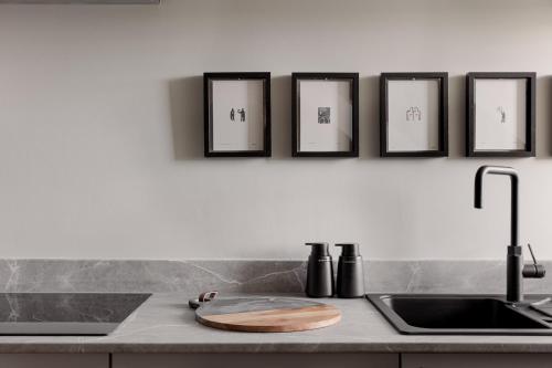 a kitchen counter with four framed pictures on the wall at Broomhill Loft in Aberdeen