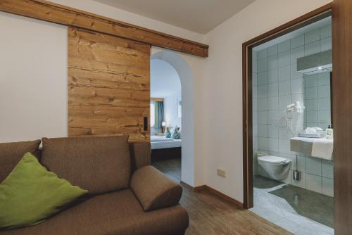 ein Wohnzimmer mit einem Sofa und einem Badezimmer in der Unterkunft Der Gollinger in Saalbach-Hinterglemm