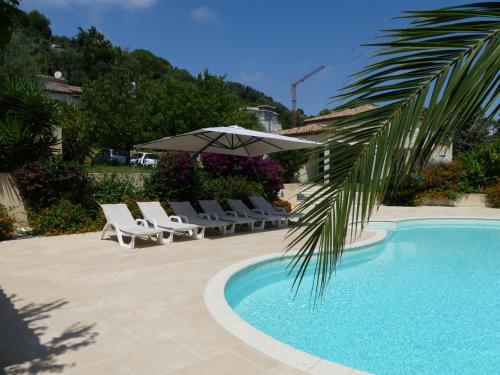 une piscine avec des chaises longues et un parasol dans l'établissement Luxueuse Villa Climatisée à Cannes, à Vallauris