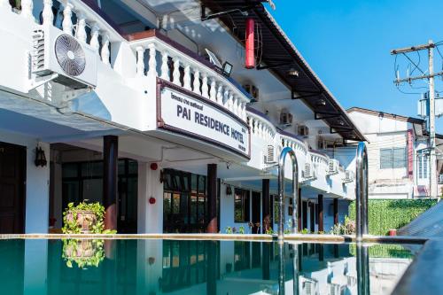 un edificio con piscina di fronte ad esso di Pai Residence Hotel a Chiang Mai