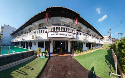 un grande edificio bianco con un cartello sopra di Pai Residence Hotel a Chiang Mai