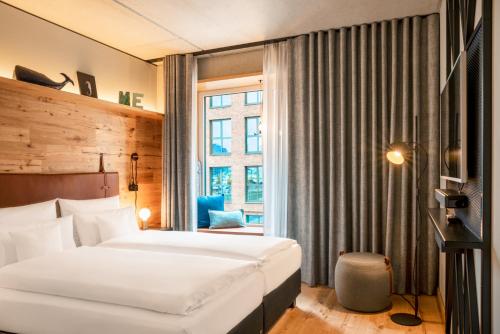 a hotel room with a bed and a window at Me and All Hotel Kiel, by Hyatt in Kiel