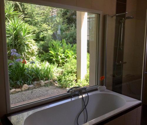une salle de bain avec une baignoire et une fenêtre dans l'établissement Luxueuse Villa Climatisée à Cannes, à Vallauris