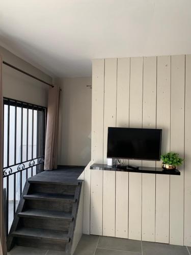 een woonkamer met een tv aan de muur bij Casa di Caribe - Deluxe beach house in Willemstad
